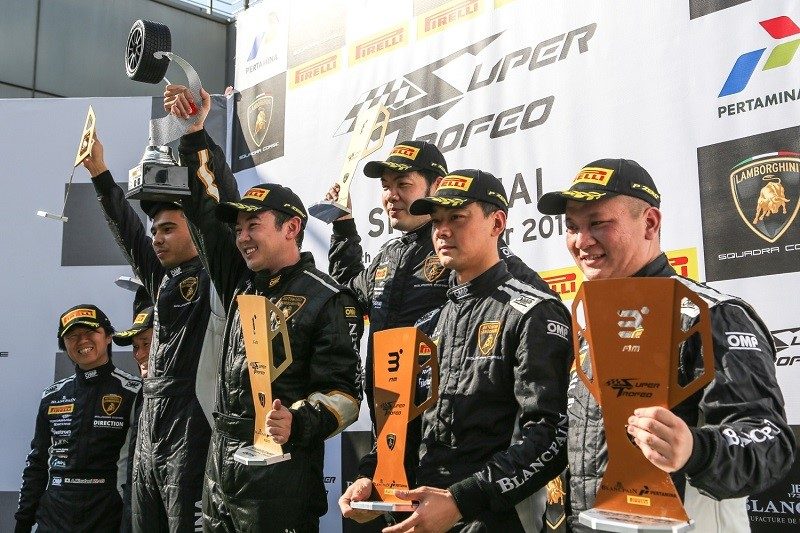 Super Trofeo race winners on the podium at China Speed Weekend holding trophies in racing suits