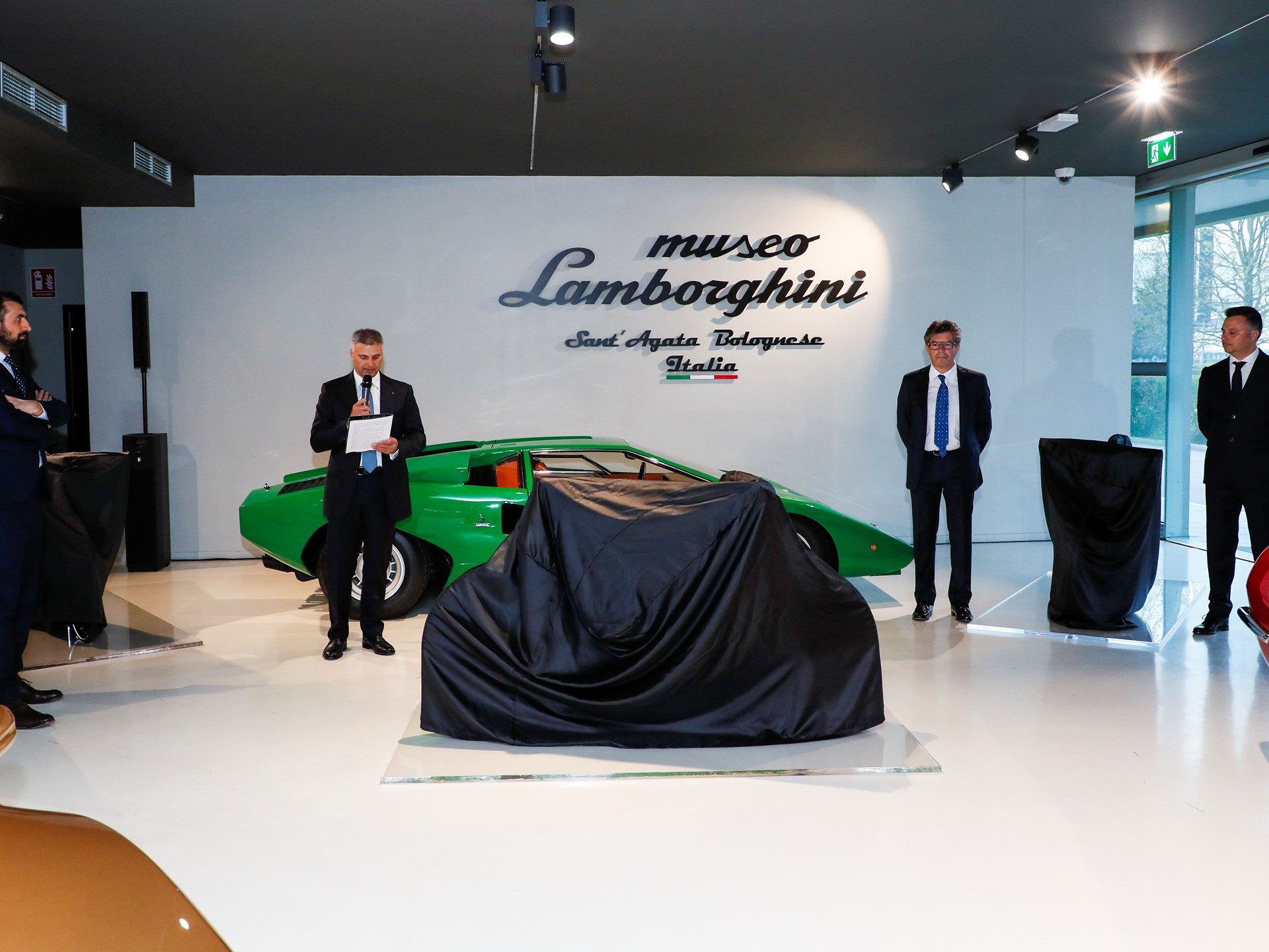 Lamborghini E-Bike unveiling event at the Museo Lamborghini in Sant'Agata Bolognese, with a green Countach LP 400 visible in the background