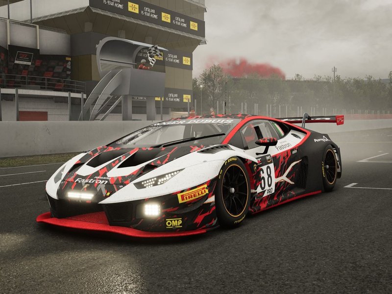 Lamborghini Huracán GT3 EVO race car with white, black, and red livery on a wet race track with grandstands and red smoke in the background