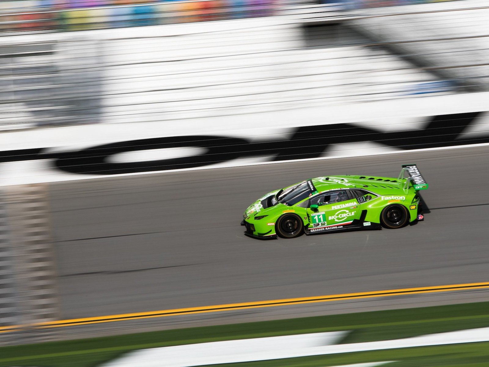 Bright green Lamborghini Huracán GT3 race car at speed on the Daytona International Speedway