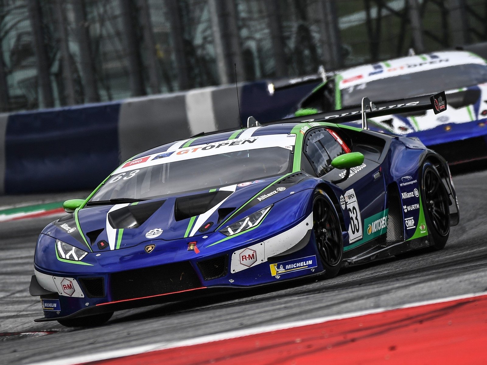 Lamborghini Huracán GT3 number 63 racing on track with aggressive aero package and large rear wing visible