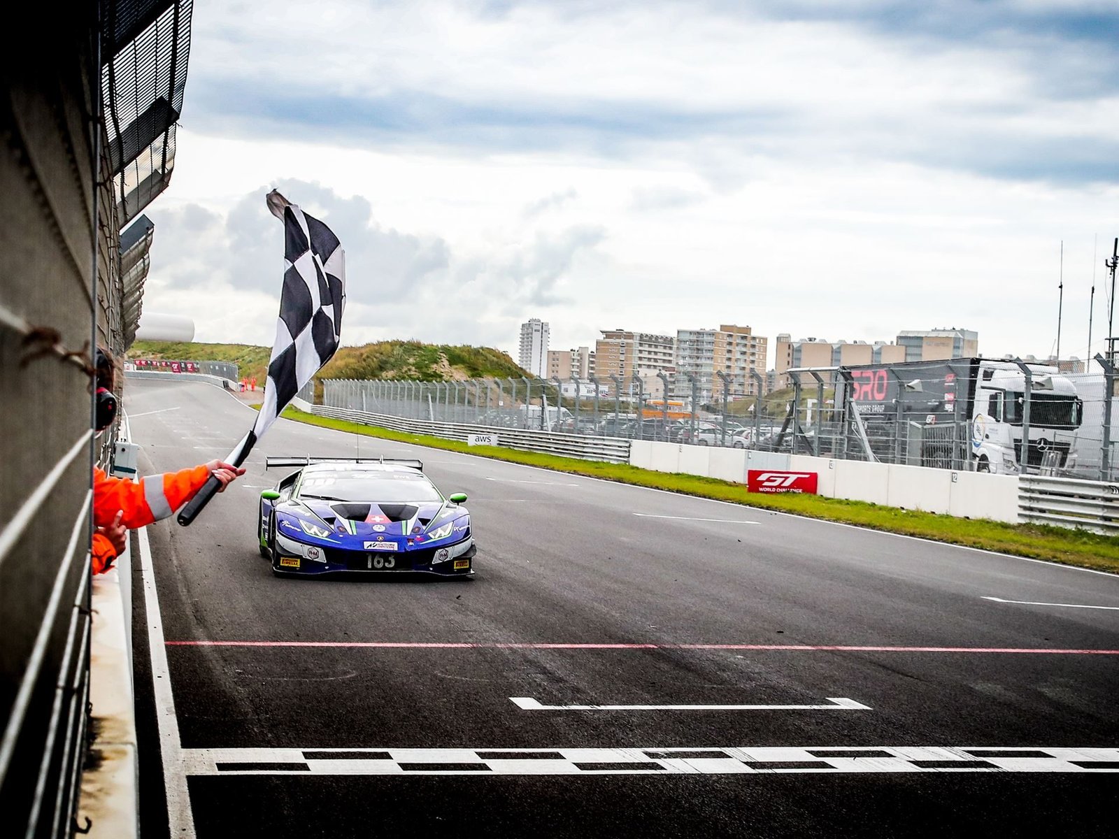Lamborghini Huracán GT3 Evo crosses the finish line under the checkered flag at Zandvoort during the 2020 GT World Challenge Europe Sprint Cup