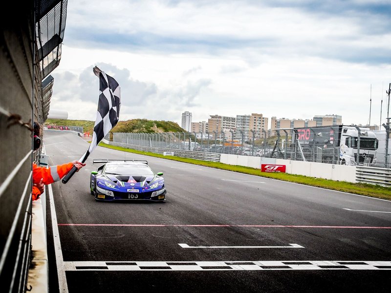 Lamborghini Huracán GT3 Evo crosses the finish line under the checkered flag at Zandvoort during the 2020 GT World Challenge Europe Sprint Cup