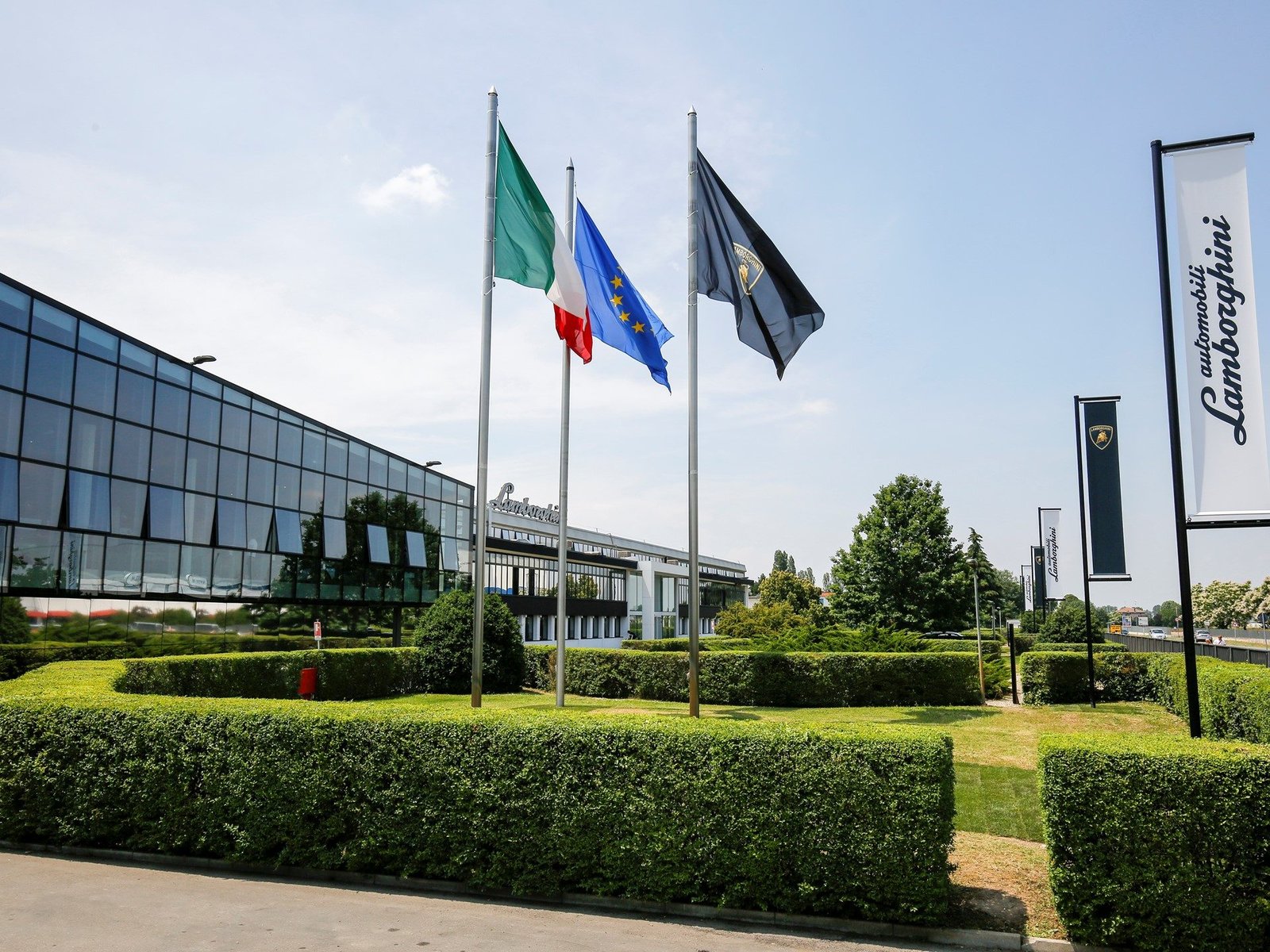 Automobili Lamborghini headquarters in Sant'Agata Bolognese with Italian, EU, and Lamborghini flags