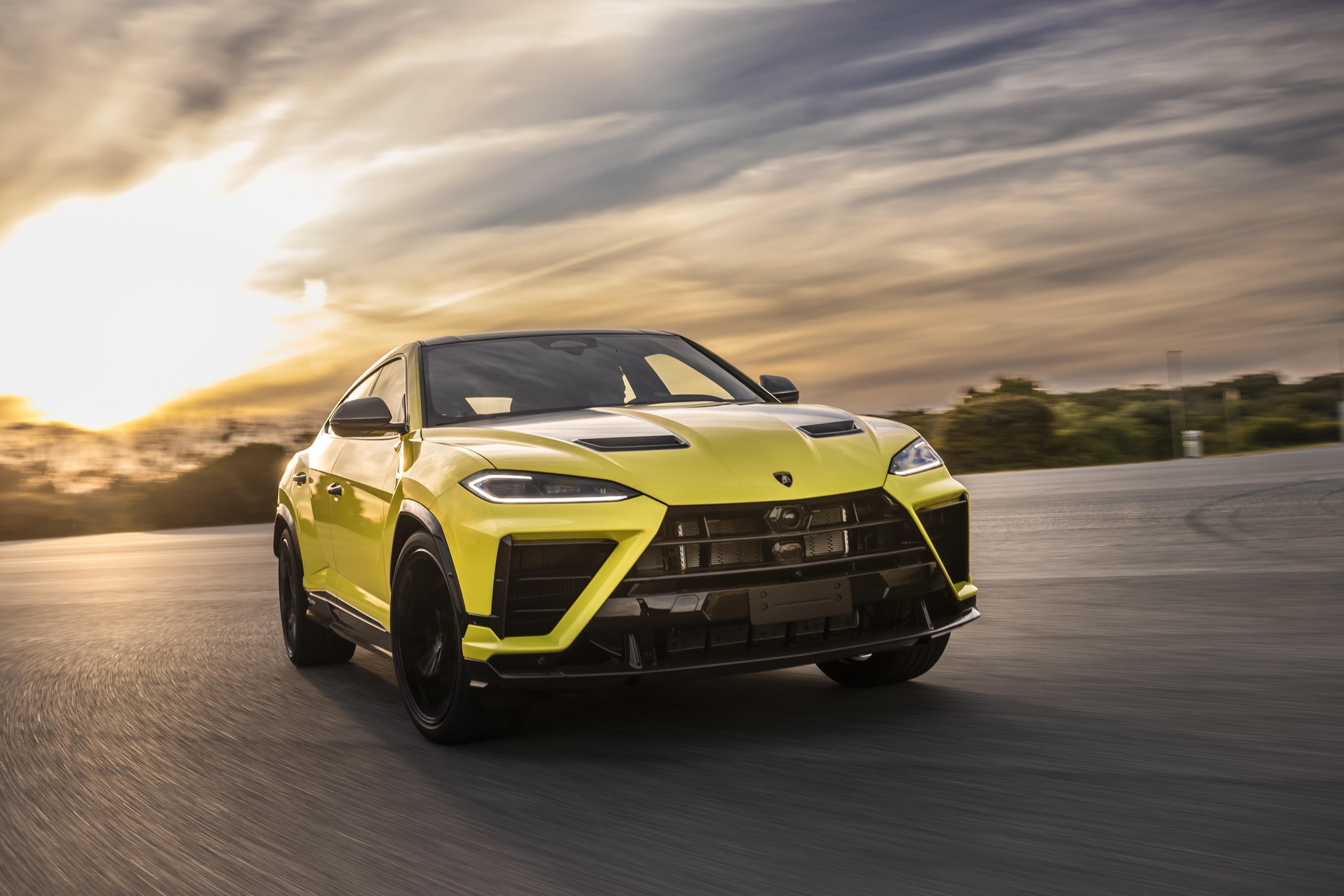 Lamborghini Sold Fewer Cars In H1 2026 And Still Posted Record Revenue. Here'S Why That Matters. 9 Yellow lamborghini urus performante driving on a track at sunset with motion blur