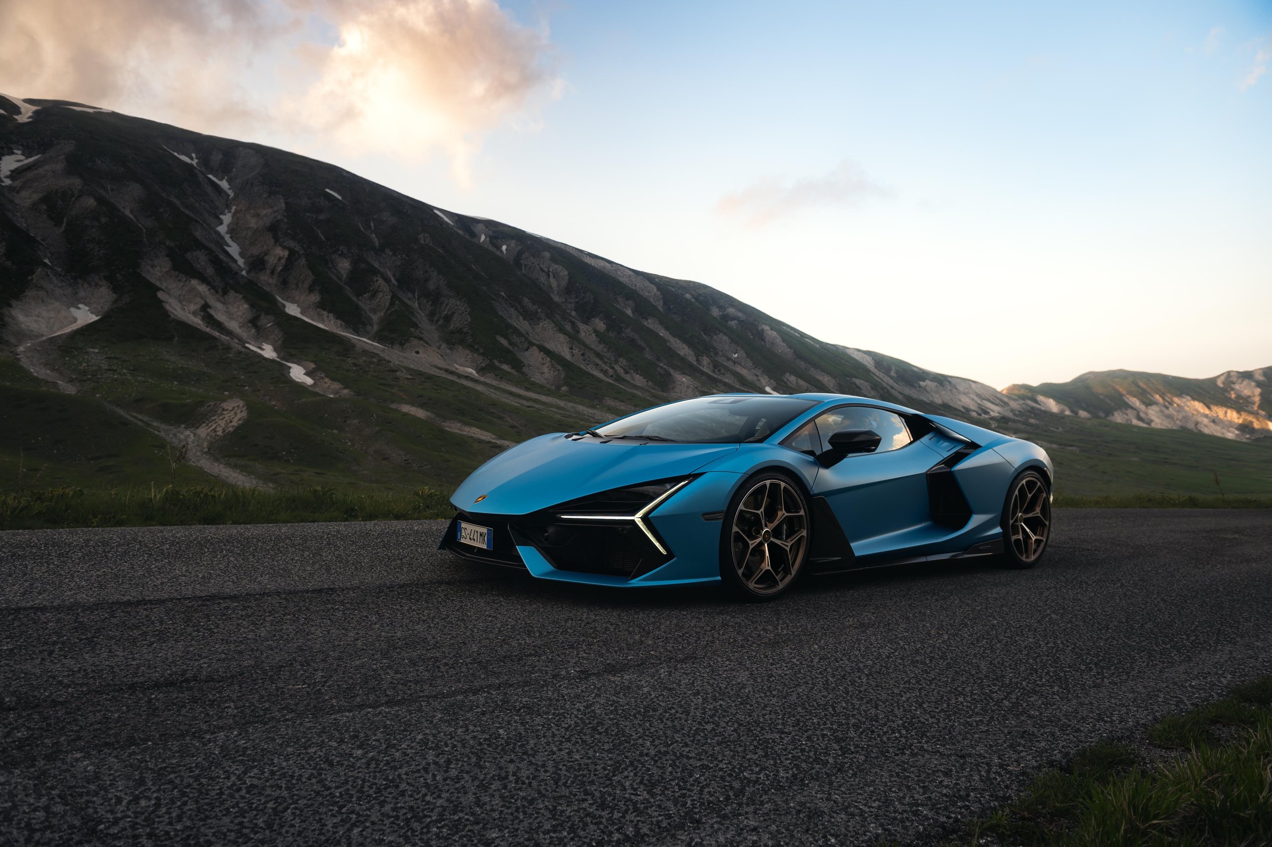 Lamborghini Sold Fewer Cars In H1 2026 And Still Posted Record Revenue. Here'S Why That Matters. 5 Blue lamborghini revuelto parked on a winding mountain road at dusk with dramatic clouds
