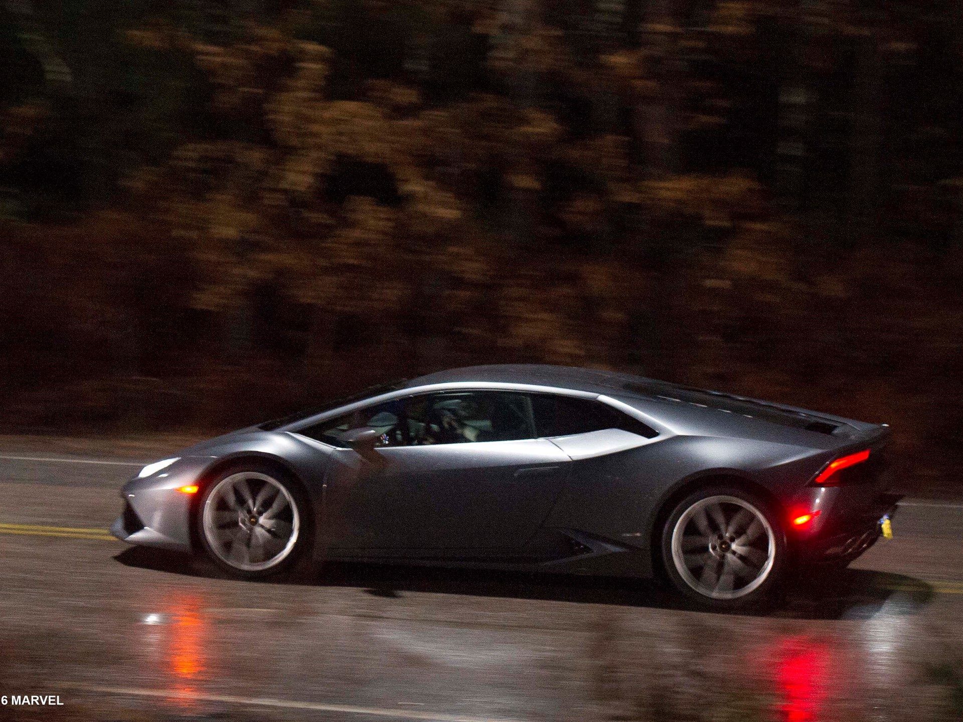 Grey Lamborghini Huracán in motion at night with visible driver, evoking the Doctor Strange driving scene