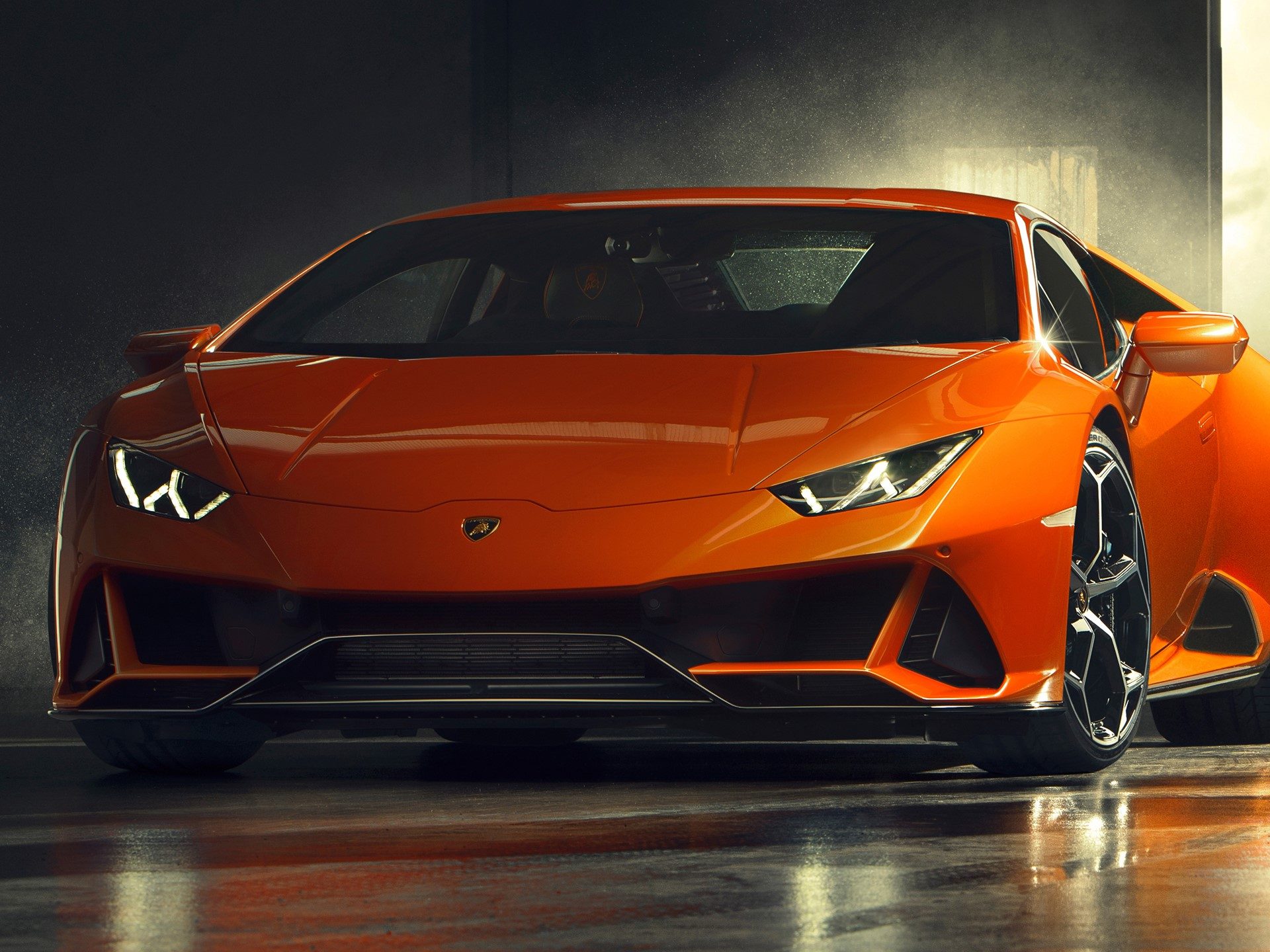Front view of the lamborghini huracán evo in arancio xanto orange, showcasing aggressive front splitter and y-shaped led daytime running lights