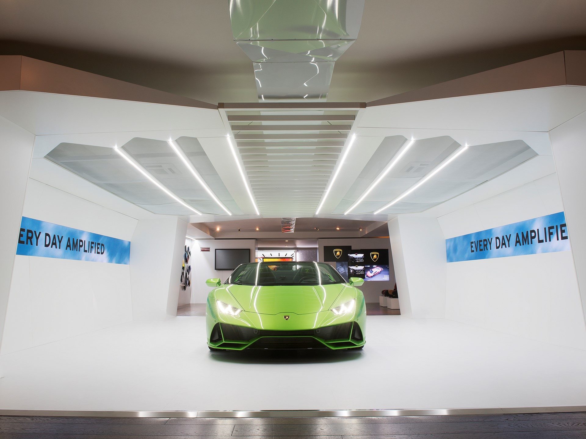 Green Lamborghini Huracán EVO in a white futuristic showroom with Every Day Amplified signage