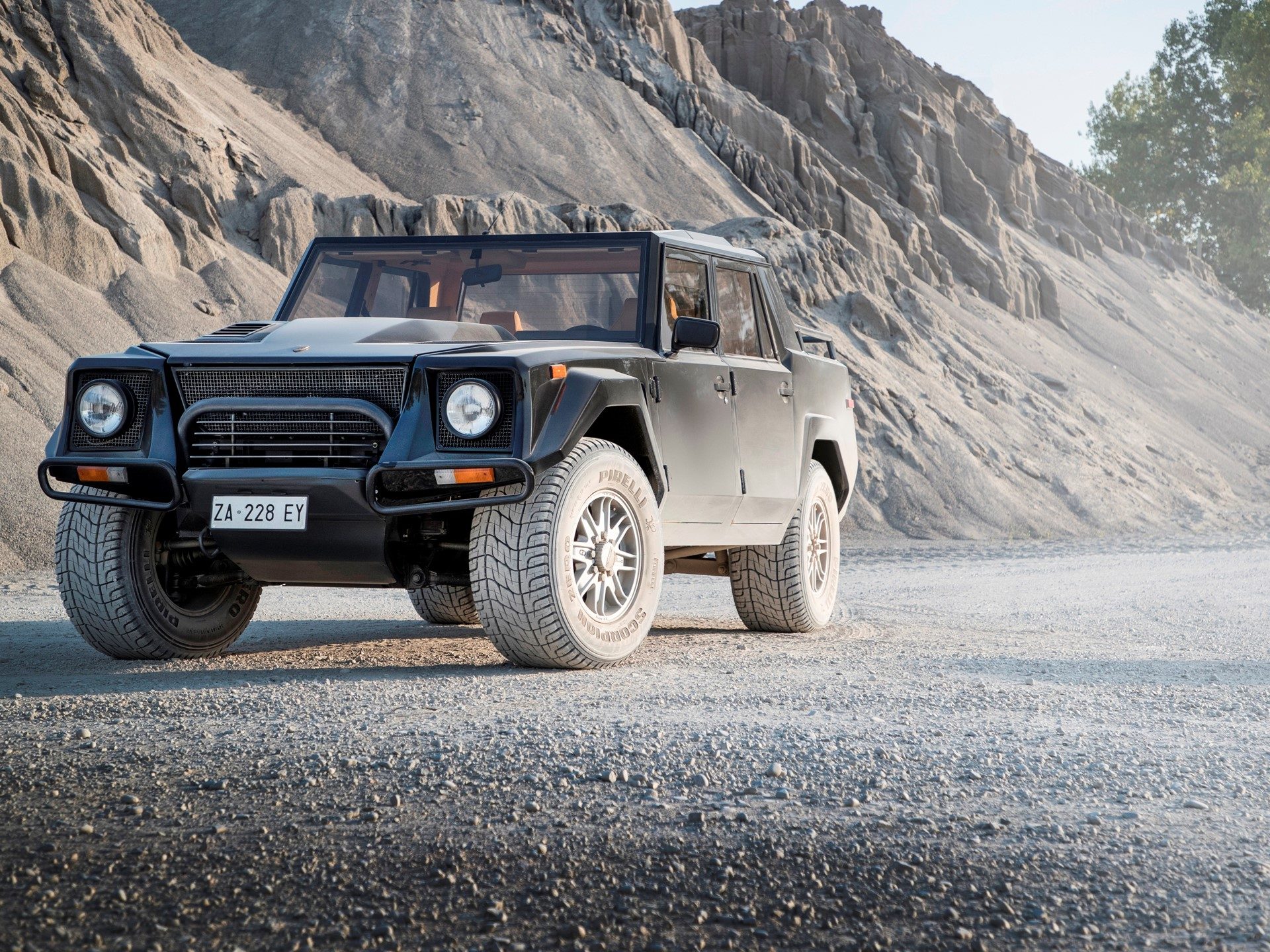 Black Lamborghini LM002 in a desert landscape showing its wide stance, large off-road tires, and high ground clearance