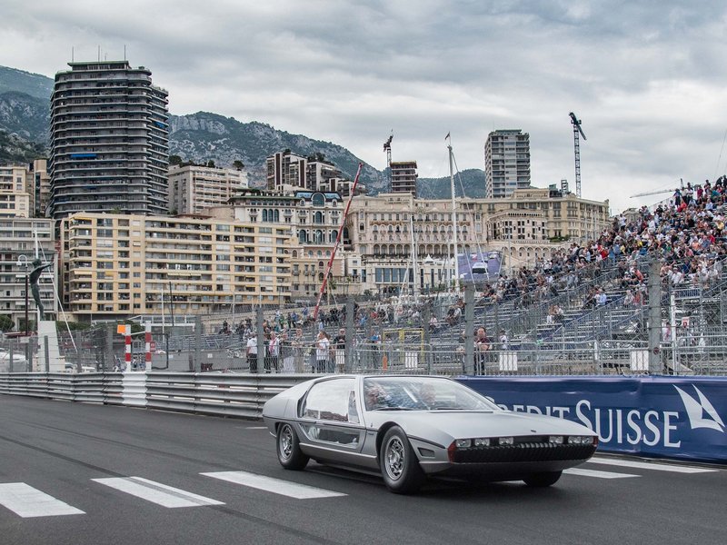 Lamborghini Marzal concept car in silver driving on the Monaco circuit under cloudy skies with spectators visible in grandstands