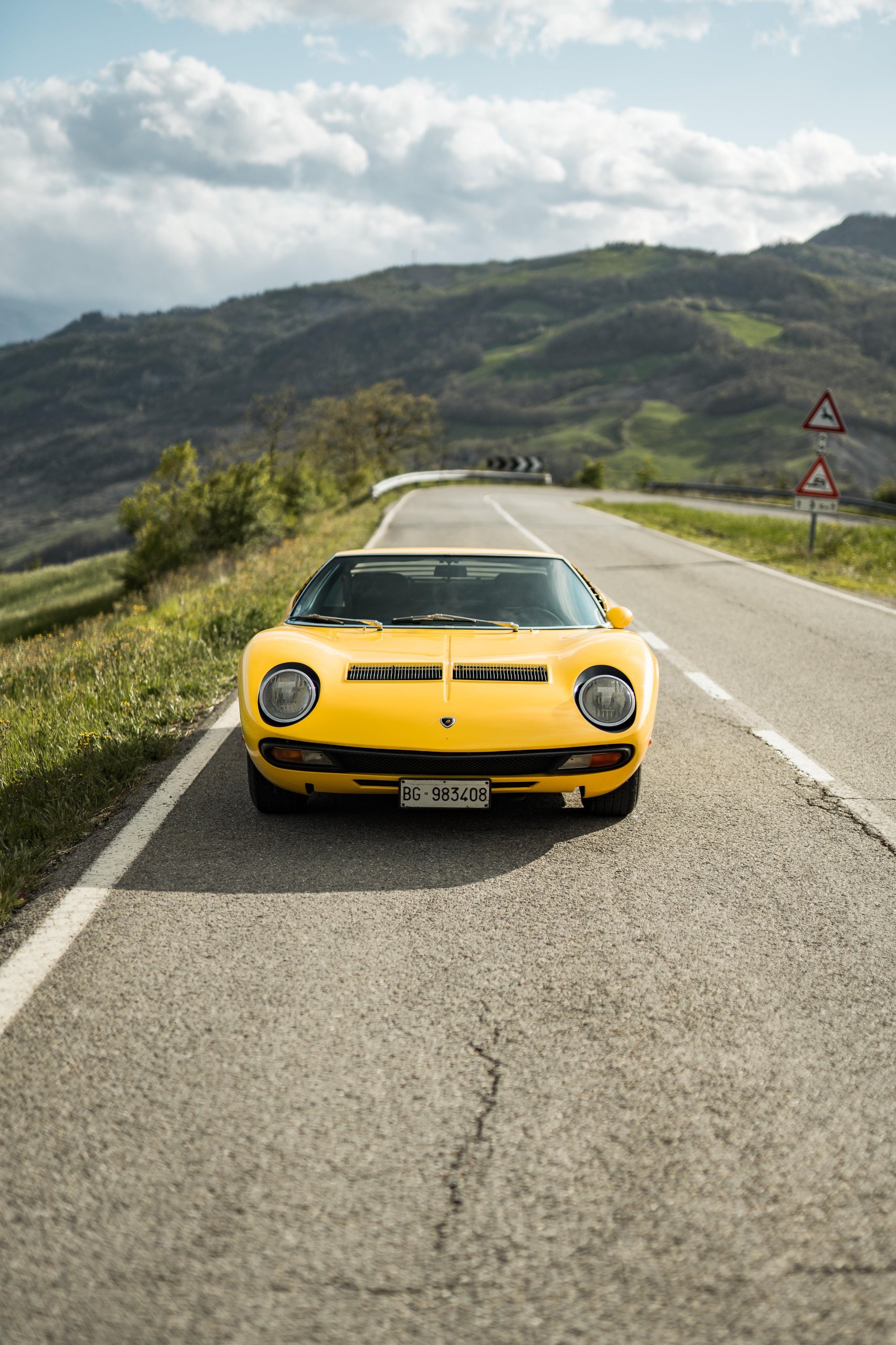 Yellow lamborghini miura sv parked head-on showing the clean front end without eyelash headlight trim