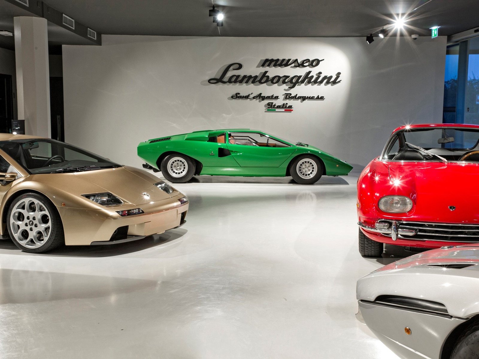 Gold Diablo, green Countach, red 350 GT, and silver Silhouette displayed inside the Lamborghini Museum