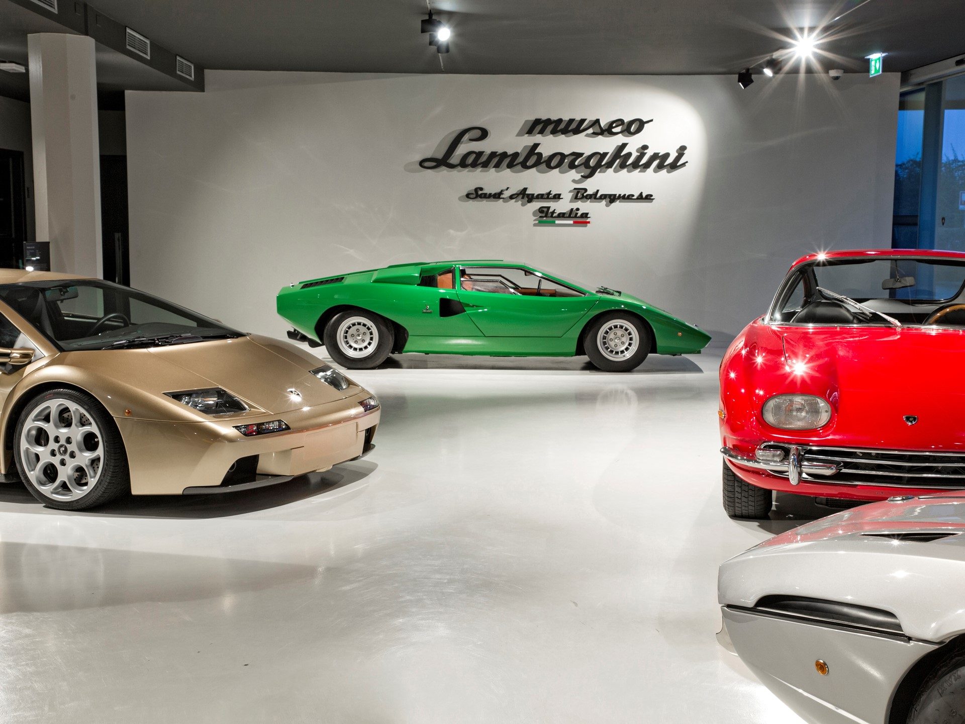 Gold Diablo, green Countach, red 350 GT, and silver Silhouette displayed inside the Lamborghini Museum