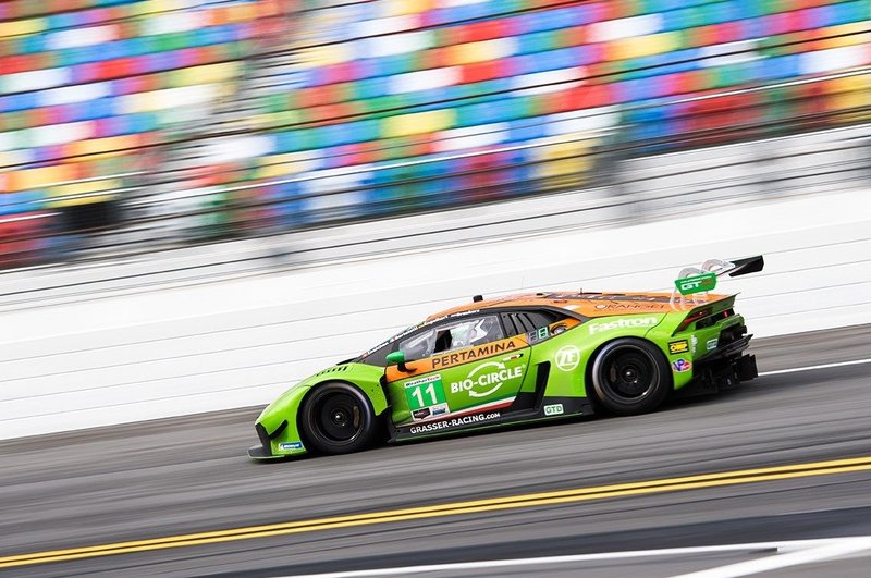 Lamborghini Huracán GT3 EVO in Pertamina livery racing at high speed with blurred grandstands in background