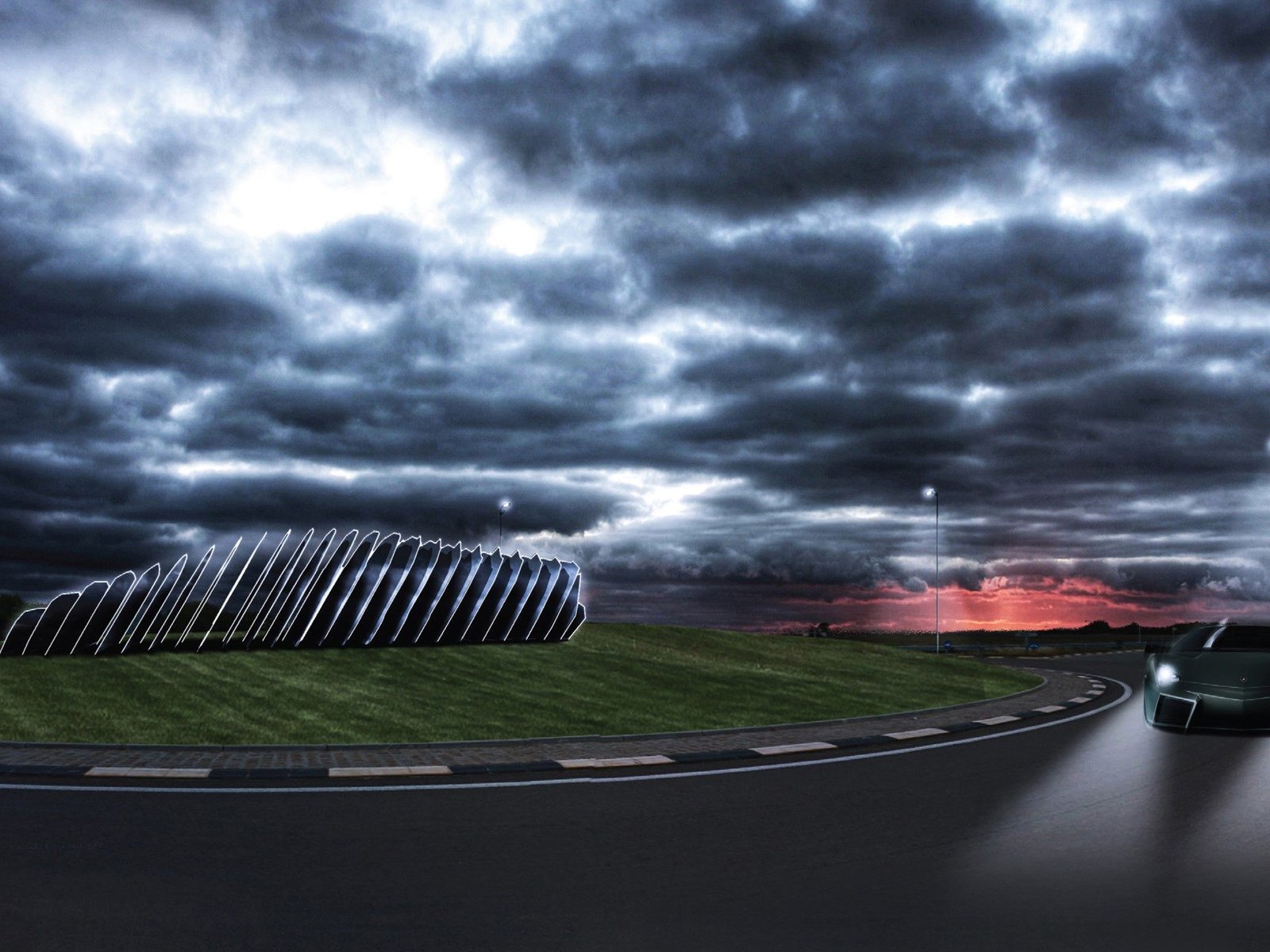 A dark grey Lamborghini Murciélago LP 640 drives on a winding road past a modern art installation under a dramatic sunset sky