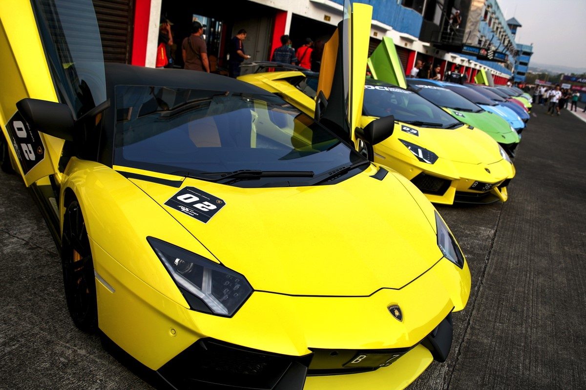 A fleet of Lamborghini supercars with scissor doors open lined up on the Sentul circuit during the Esperienza customer event