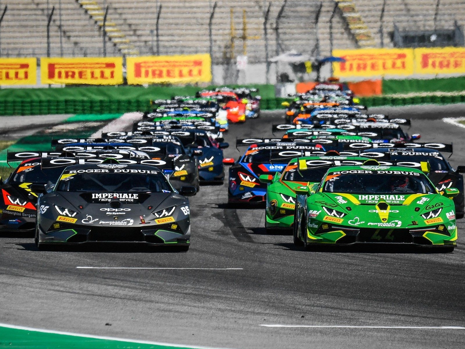 Lamborghini Huracán Super Trofeo EVO race cars battling on track with Pirelli banners visible in the background