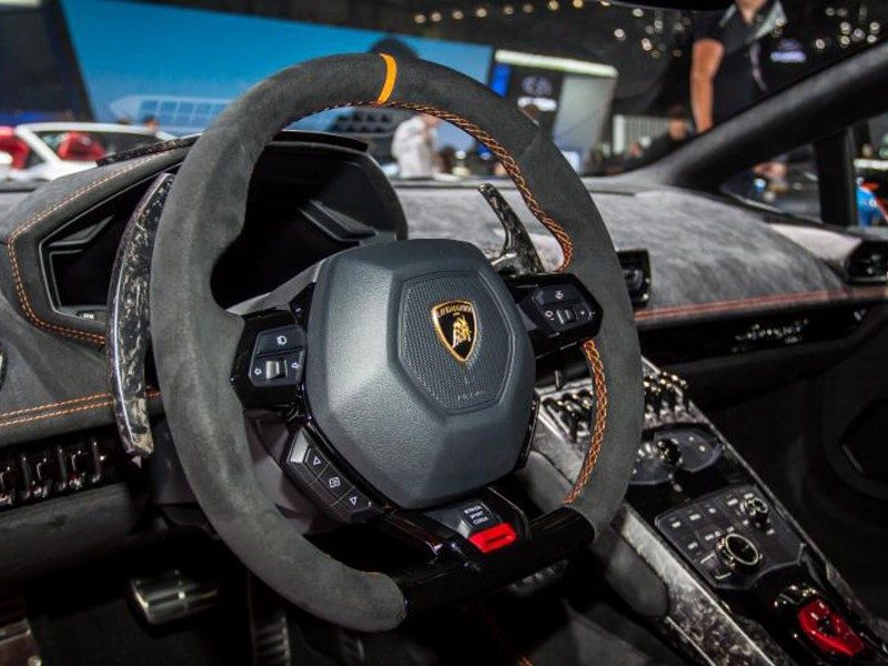Lamborghini Huracán steering wheel with grey Alcantara trim, orange contrast stitching, and carbon fiber paddle shifters