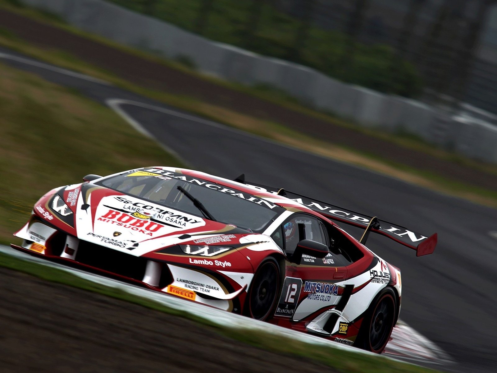 Lamborghini Huracán Super Trofeo race car in red, white, and black livery at speed on a circuit