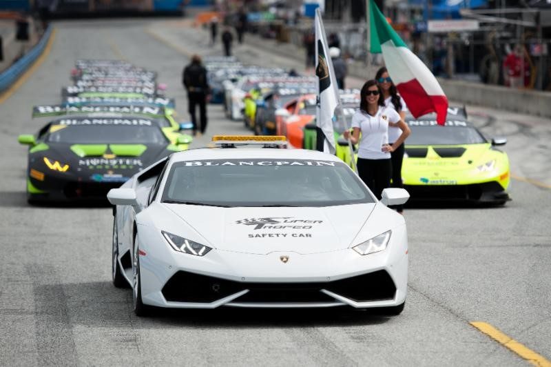 Lamborghini Huracán safety car leading Super Trofeo race cars on circuit with Italian and Lamborghini flags visible