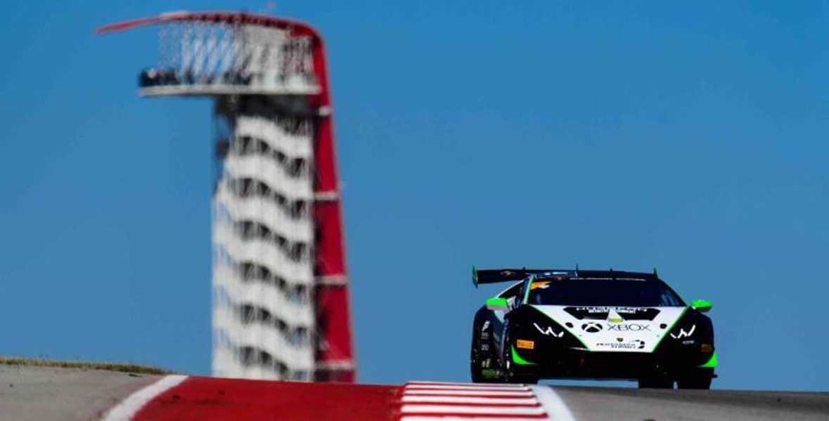 Lamborghini Huracán Super Trofeo race car speeding on track at Circuit of The Americas with the iconic COTA observation tower in the background