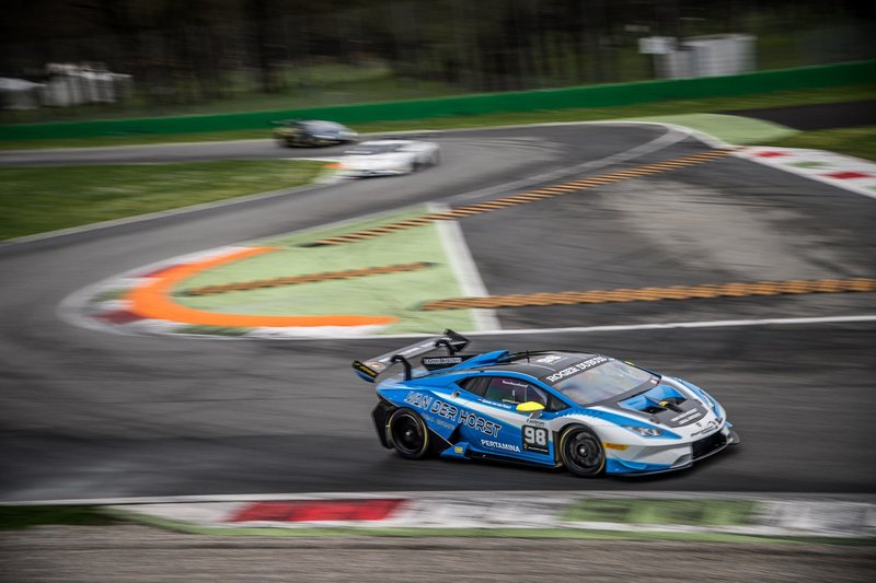 Blue and white Lamborghini Huracán Super Trofeo race car at speed on circuit with motion blur