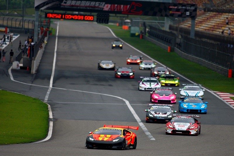 A pack of multi-colored Lamborghini Huracán Super Trofeo race cars battle for position on the Shanghai International Circuit during China Speed Weekend