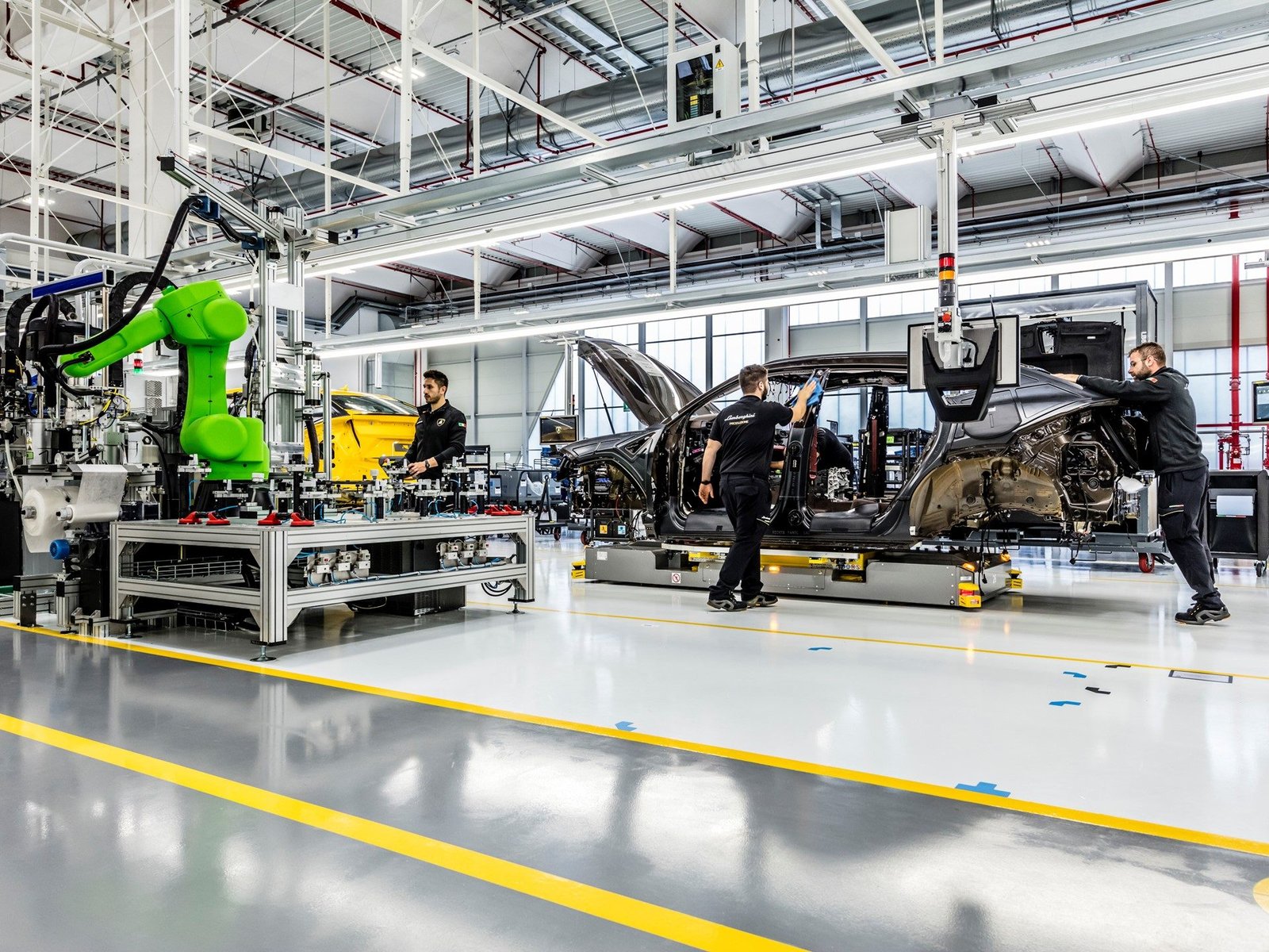 Lamborghini Urus assembly line with technicians working alongside robotic automation at the Sant'Agata Bolognese factory