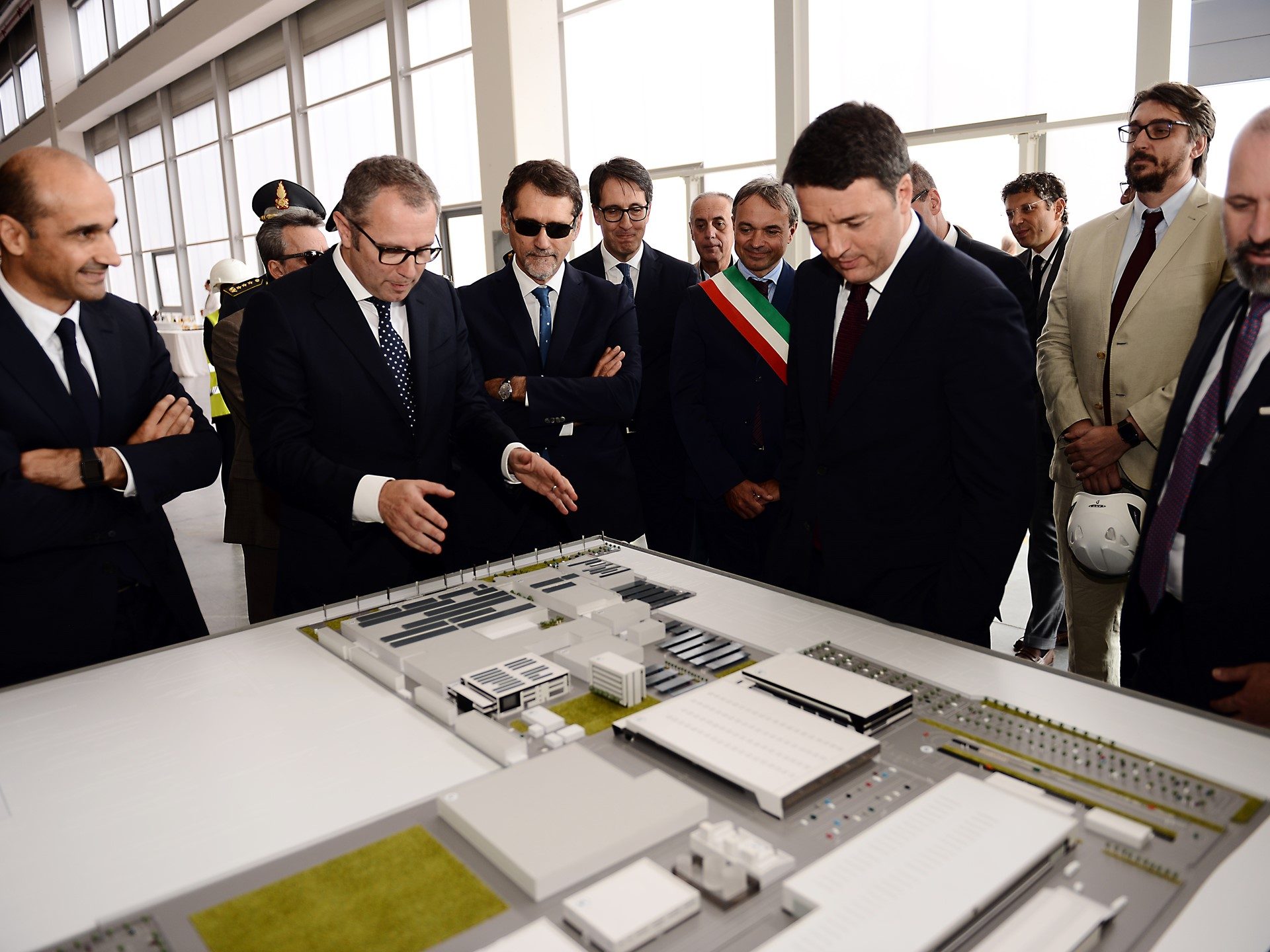 Officials and Lamborghini executives examine an architectural model of the expanded factory campus at Sant'Agata Bolognese