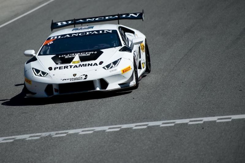 White lamborghini huracán lp 620-2 super trofeo race car at speed on track with visible rear wing and carbon fiber aero elements