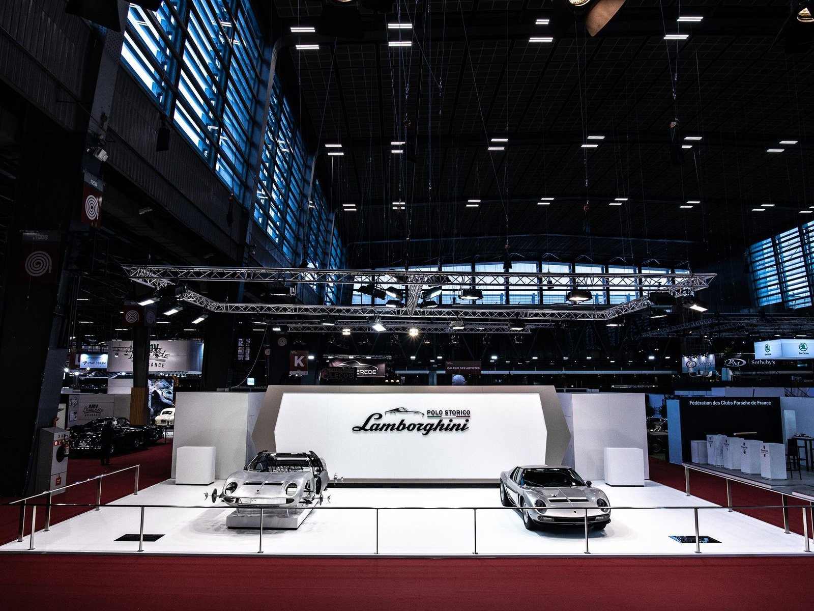 Lamborghini Polo Storico exhibition stand at Rétromobile showing two silver Miura models on white display platforms with the Polo Storico branding