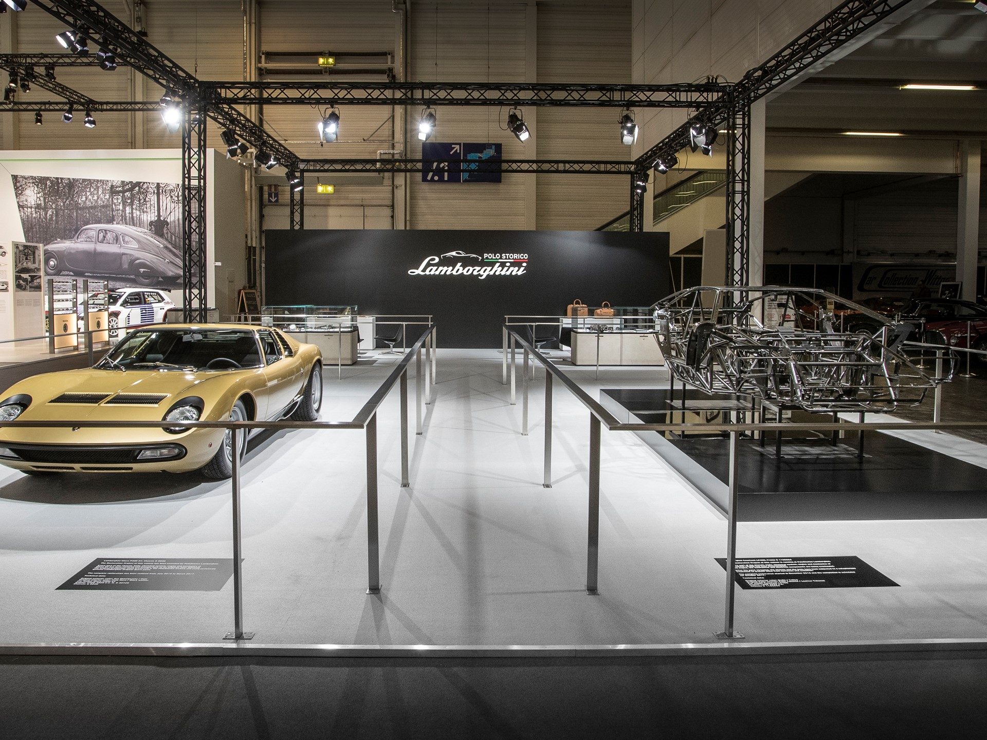 Gold Lamborghini Miura P400 SV displayed alongside a bare Countach LP400 Periscopio chassis at Lamborghini Polo Storico's Techno Classica stand