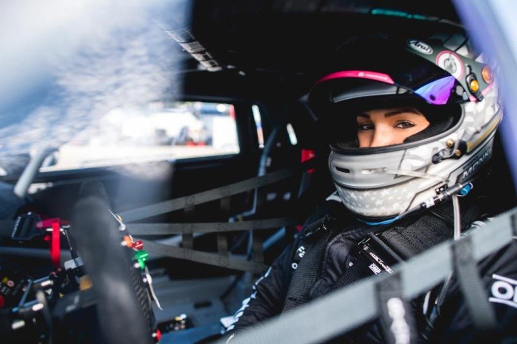 Sheena Monk in her racing helmet looking directly at the camera from inside the cockpit of her Lamborghini Huracán Evo Super Trofeo