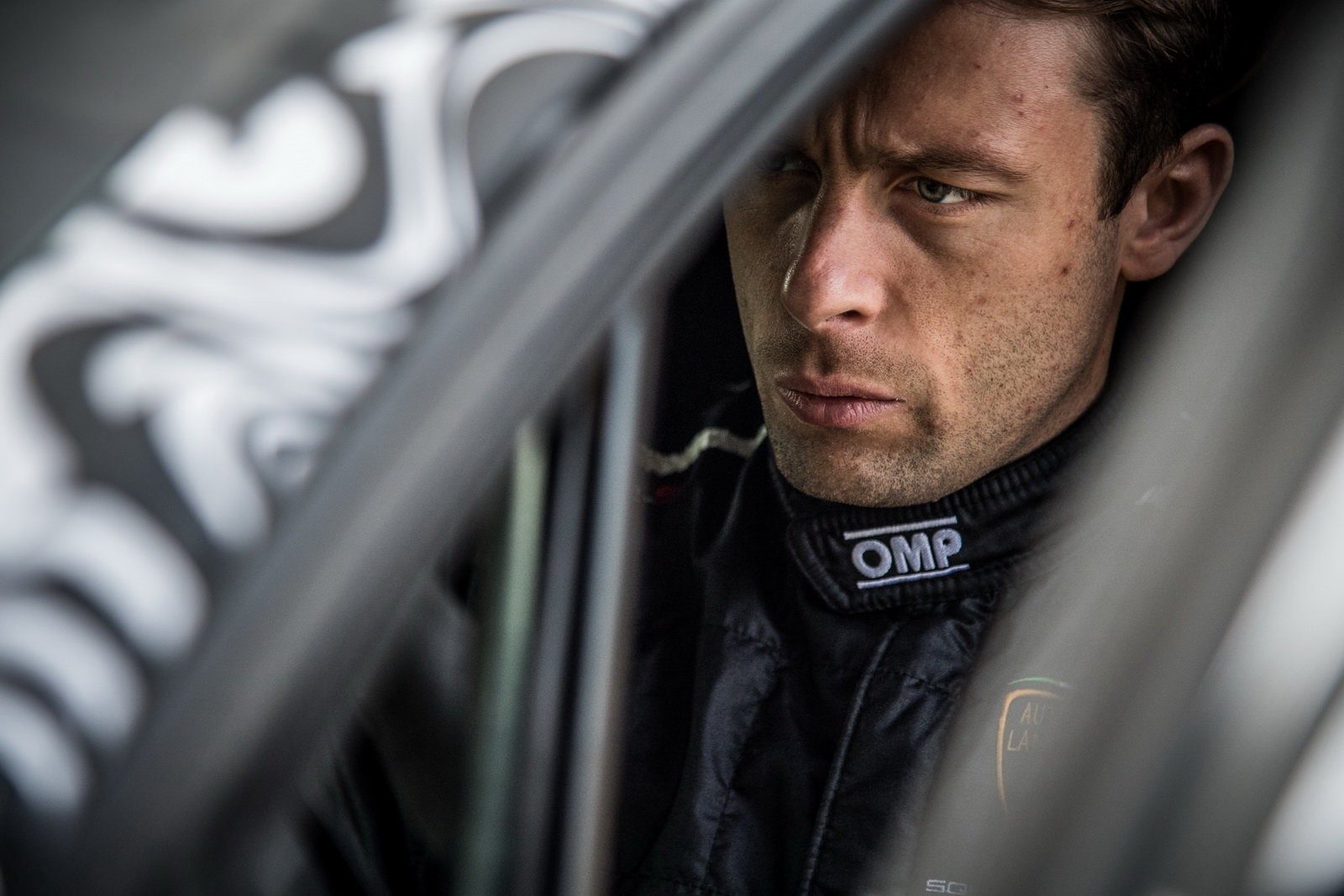 Lamborghini Squadra Corse factory driver portrait through roll cage wearing black OMP racing suit