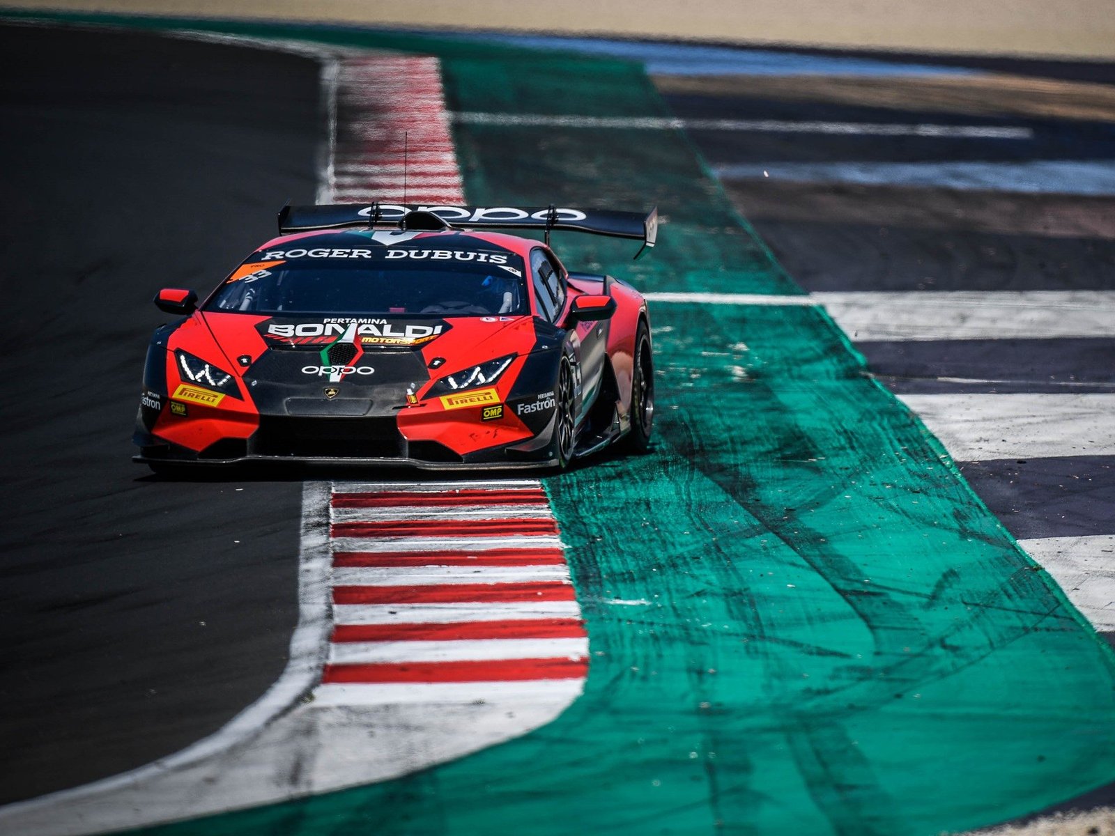 Red and black Bonaldi Motorsport Lamborghini Huracán Super Trofeo Evo racing through a corner at Misano Adriatico with visible Roger Dubuis and Pertamina sponsorship