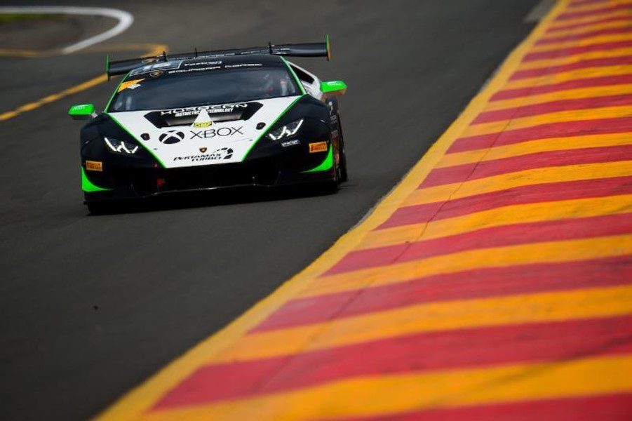 A Lamborghini Huracán Super Trofeo race car at speed on a circuit, showing its large rear wing, aggressive front aero, and racing slick tires.
