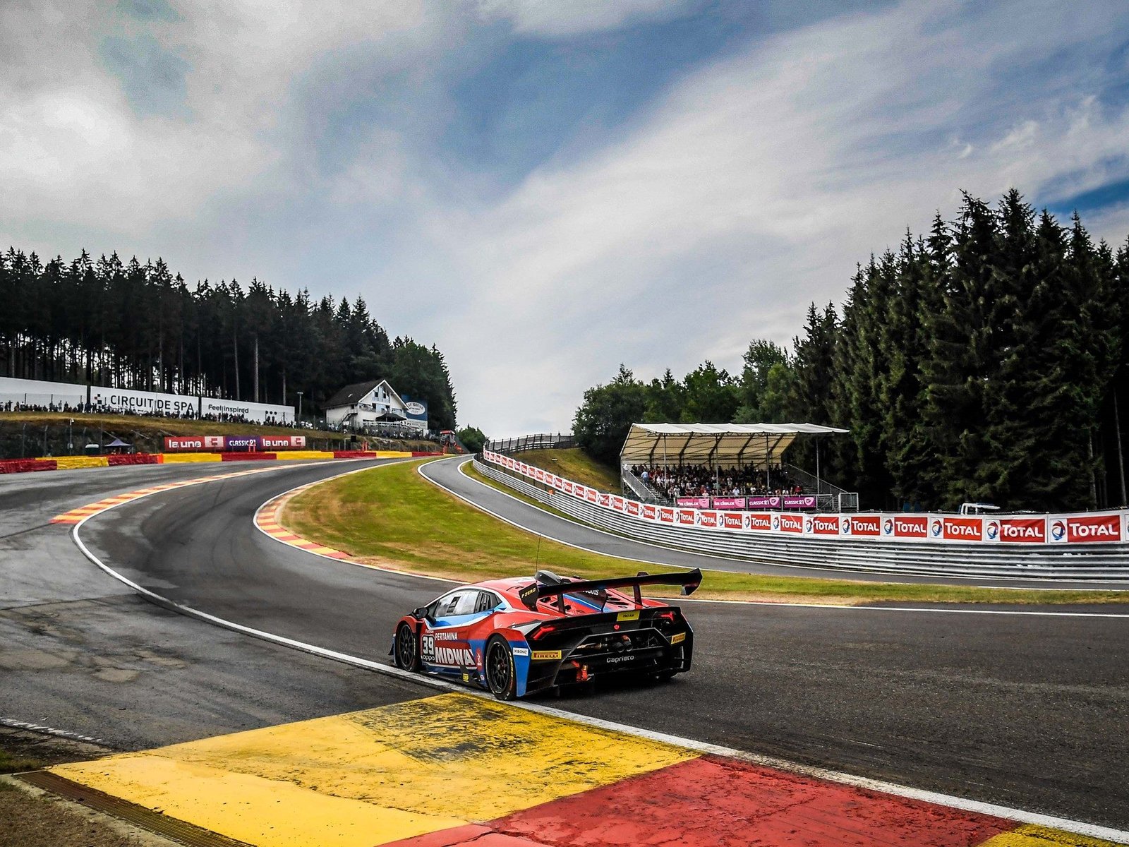Lamborghini Huracan Super Trofeo EVO number 39 navigating a corner at Spa-Francorchamps with spectators in the grandstands
