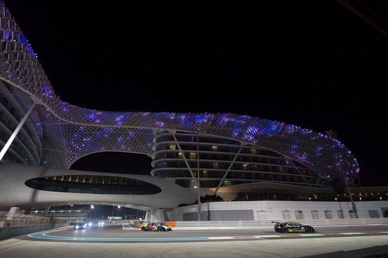 Lamborghini Huracán Super Trofeo racing under floodlights at Yas Marina circuit with the illuminated Yas Hotel in the background