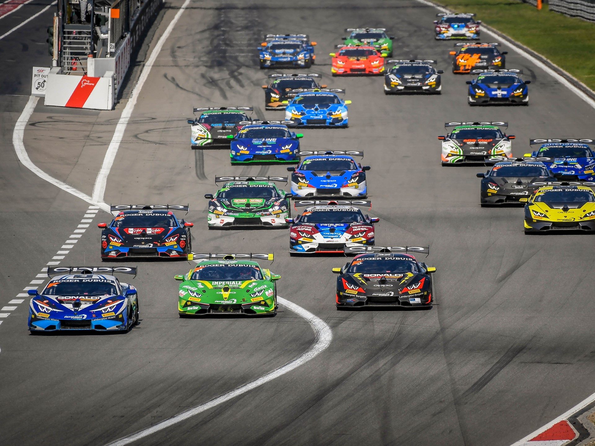 Full grid of Lamborghini Huracán Super Trofeo Evo race cars in colorful liveries competing on track