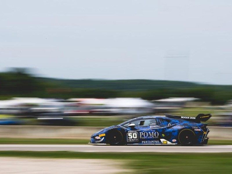 Blue Lamborghini Huracán Super Trofeo race car at speed on track with motion blur