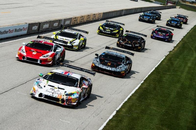 Multiple Lamborghini Huracán Super Trofeo race cars in colorful liveries battling on track at Road America