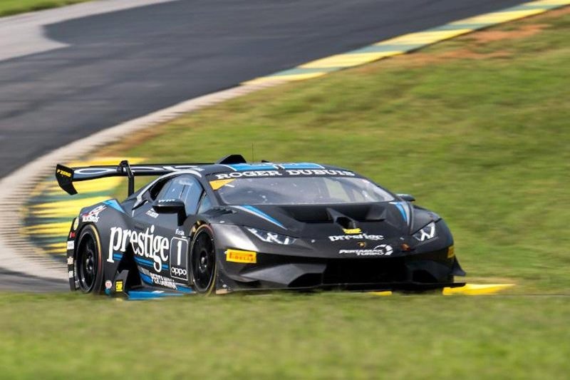 A black Lamborghini Huracán Super Trofeo EVO race car with blue and white livery mid-turn at VIRginia International Raceway