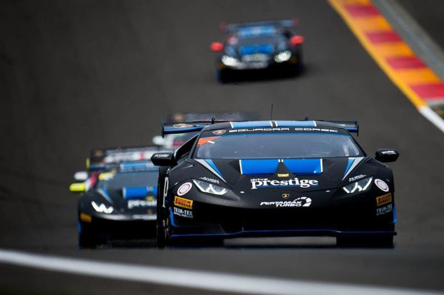 Black Lamborghini Huracan Super Trofeo race car with blue accents leading competitors on track at Watkins Glen International
