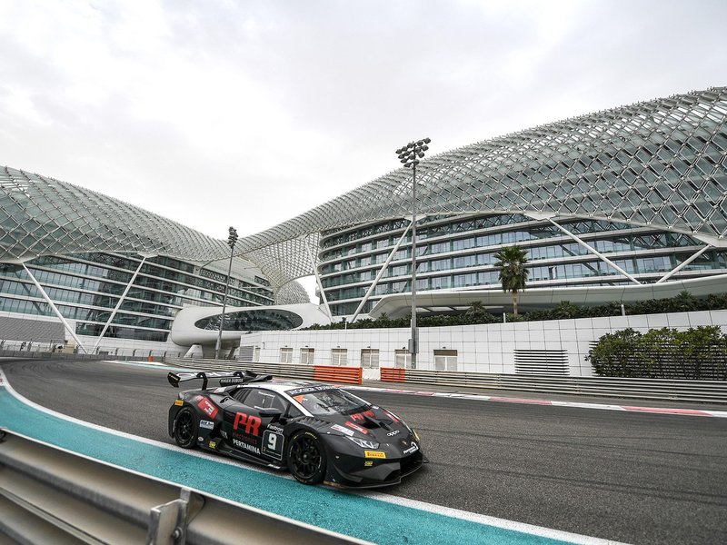 Lamborghini Huracán Super Trofeo EVO at Yas Marina Circuit with aggressive roof scoop and rear wing visible under circuit lighting