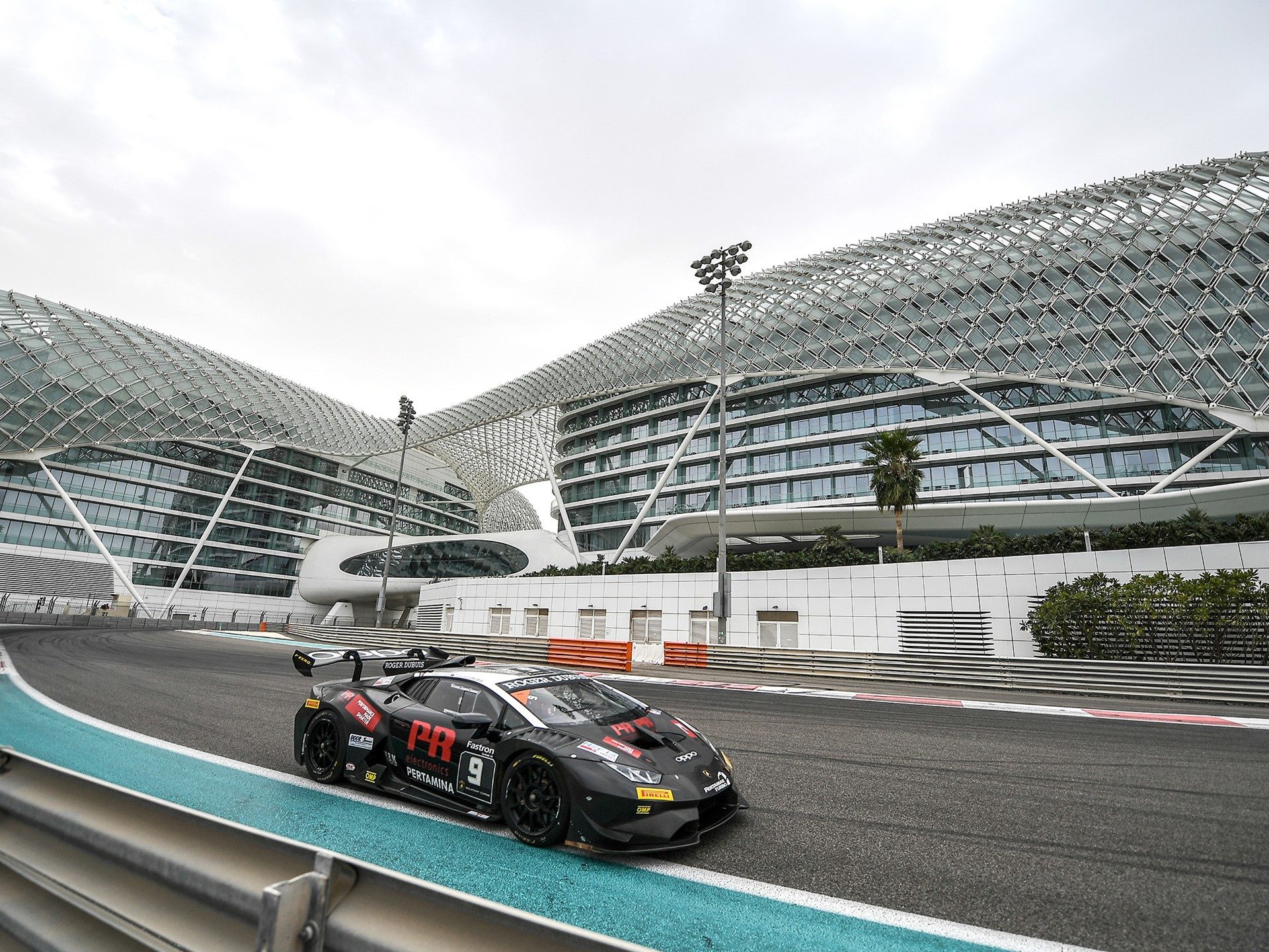 Lamborghini Huracán Super Trofeo EVO at Yas Marina Circuit with aggressive roof scoop and rear wing visible under circuit lighting