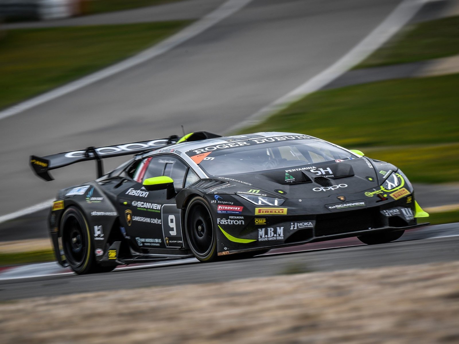 Black Lamborghini Huracán Super Trofeo EVO race car with neon green accents at speed on track with motion blur