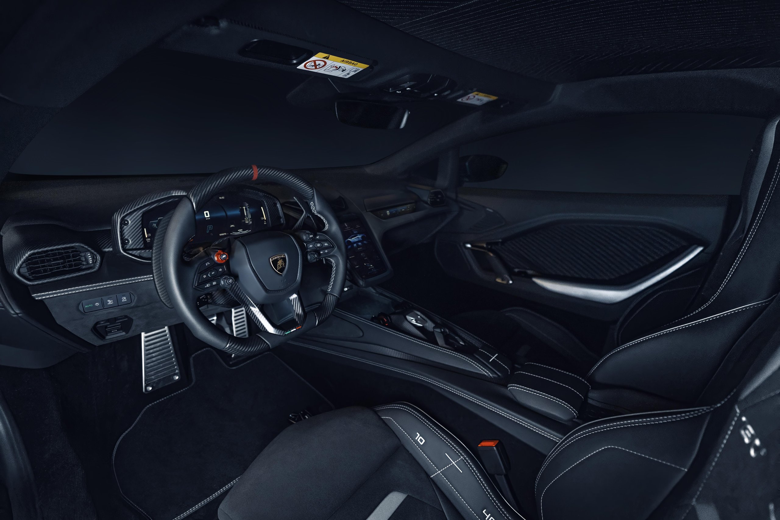 The luxurious black interior of the Lamborghini Temerario concept, featuring a multi-function steering wheel, digital displays, and premium materials.