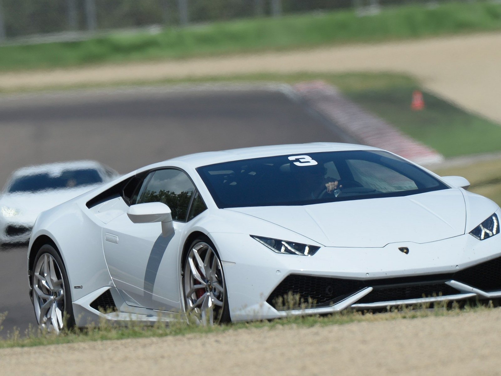 White Lamborghini Huracán LP 610-4 in action on a racetrack during a Lamborghini Accademia session