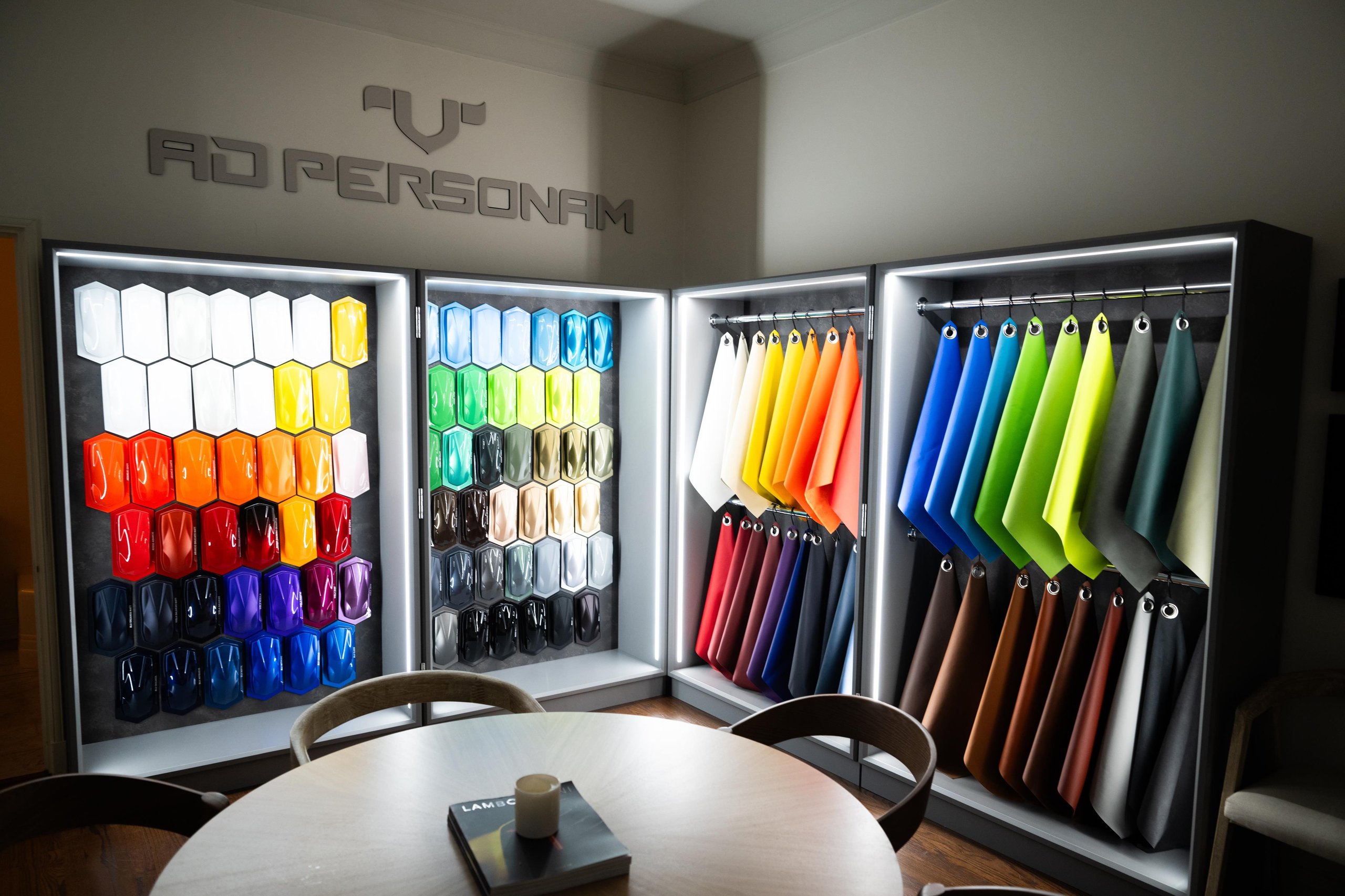 Indoor display of Lamborghini Ad Personam customization options showing rows of paint samples and leather swatches